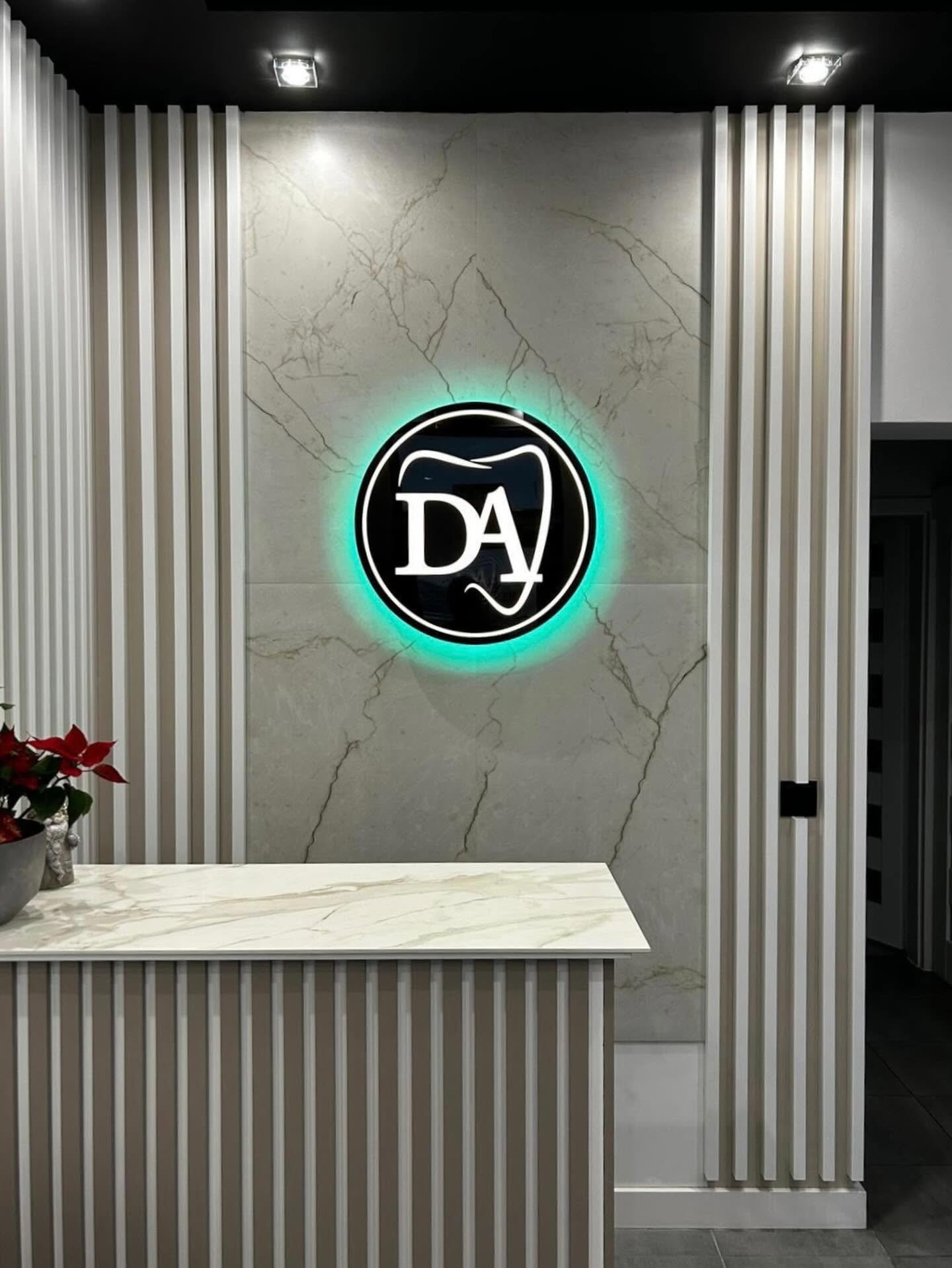 Podświetlane logo Dentis Artis na ścianie z efektem halo