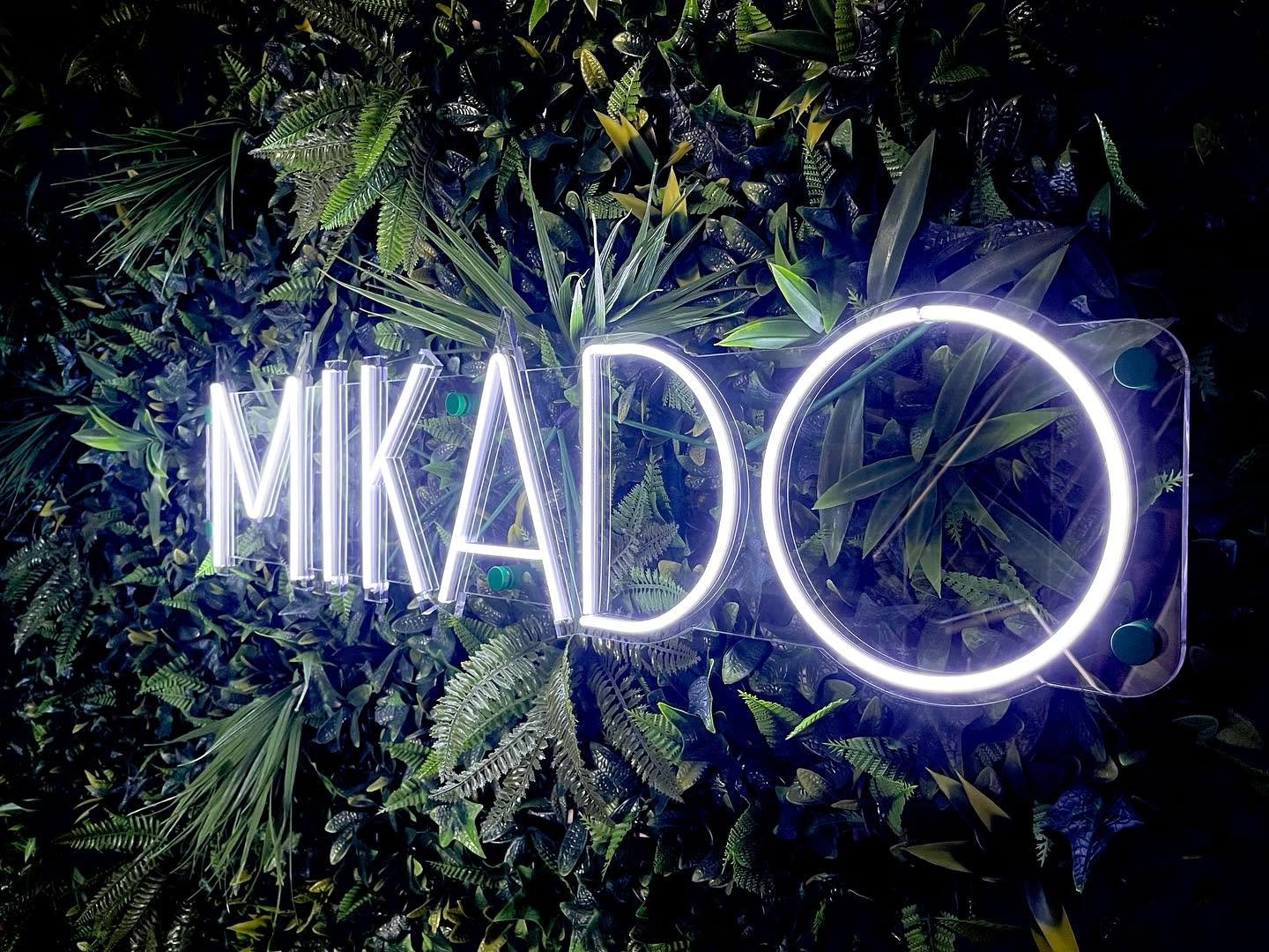 Świetlny napis MIKADO na tle zielonej ściany